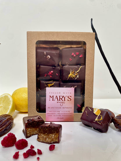 Rauwe pinda-dadel bonbons met vanille, framboos en sinaasappel. 